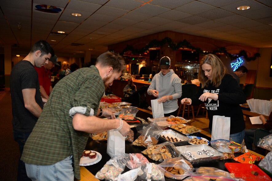 Volunteers of the 2015 Airmen Cookie Drive prepare bags of cookies at Minot Air Force Base, N.D., Dec. 11, 2015. More than 15,000 cookies were donated to give to single Airmen living in the dorms and for Airmen working during the holidays. (U.S. Air Force photo/Airman 1st Class Matt Rauschnot)