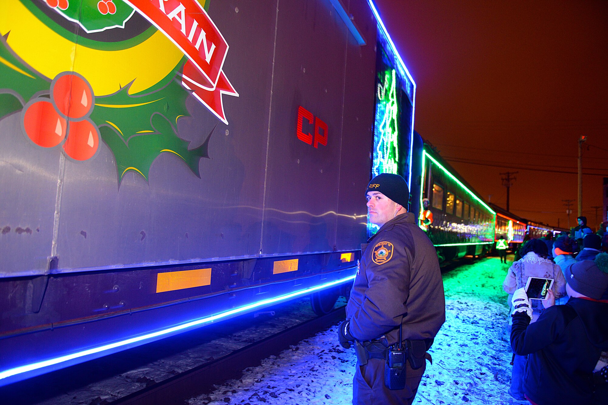 A sheriff deputy of Ward County, N.D., ensured public safety as the Canadian Pacific Holiday Train stops at the Old Soo Depot Transportation Museum in Minot, N.D., Dec. 15, 2015. The train visits communities in Quebec, New York and southern Ontario before traveling across states in the northeast and Midwest, before returning to Canada for its final stops in Saskatchewan and Alberta. The train features 14 railcars decorated with hundreds of thousands of lights and holiday-themed performances by professional musicians. (U.S. Air Force photo/Airman 1st Class Matt Rauschnot)