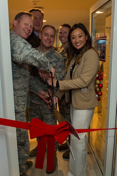 USO members and 52nd Fighter Wing leadership perform a ribbon-cutting ceremony to officially open the USO at Spangdahlem Air Base, Germany, Dec. 16, 2015. The USO will provide food, beverages, books, games and access to electronics for Airmen and their families. The USO is located on the first floor of building 126. (U.S. Air Force photo by Airman 1st Class Luke Kitterman/Released)