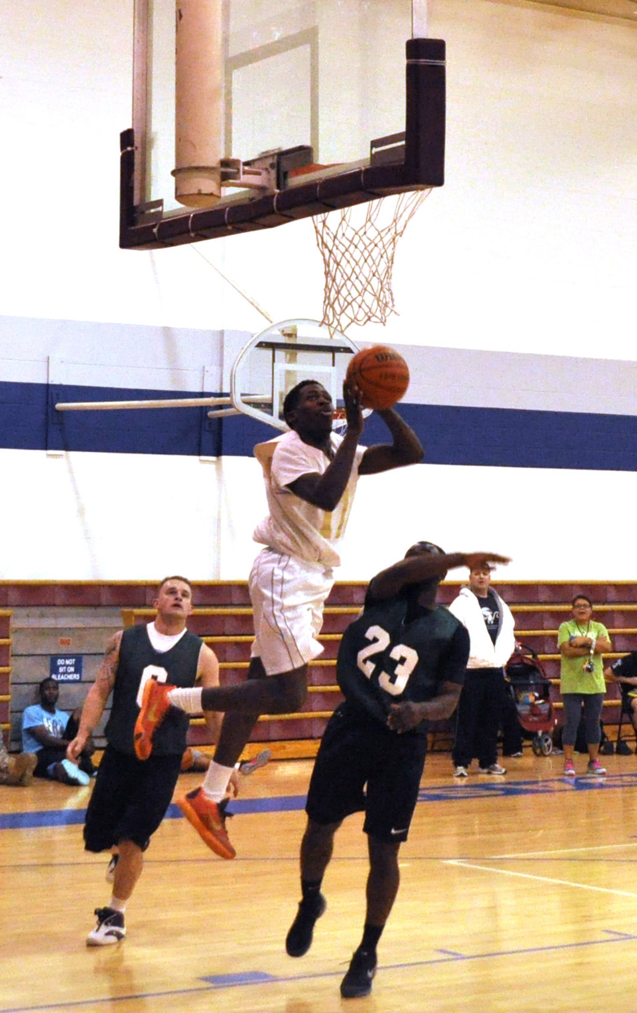 72 MDG’s Zhamar McAdory leaps for a shot between Security Forces’ Travis White, left, and Joseph Currie, in the Dec. 9 contest that Med Group won 59-40 at the Gerrity Fitness Center. Games will resume Jan. 11 after a holiday break and a week to install new bleachers in the gym.  (Air Force photos by John Parker/Released)