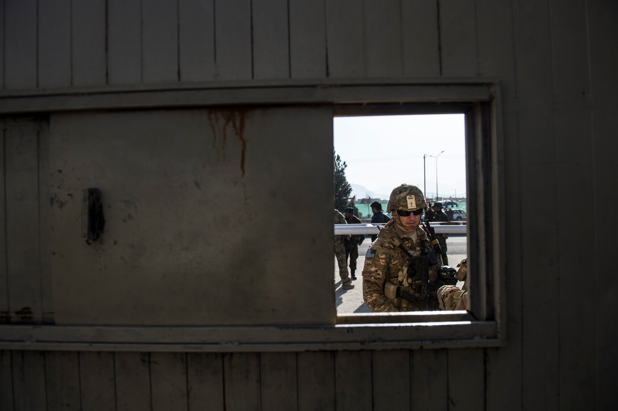 (Left) U.S Air Force Tech. Sgt. Beau Hanson visits with Afghan Air Force soldiers near Forward Operating Base Oqab, Kabul, Afghanistan, Dec. 13, 2015. Hanson is assigned to the Train, Advise, Assist Command-Air (TAAC-Air) security forces and is deployed from Sheppard Air Force Base, Texas. (U.S. Air Force photo by Staff Sgt. Corey Hook/Released)