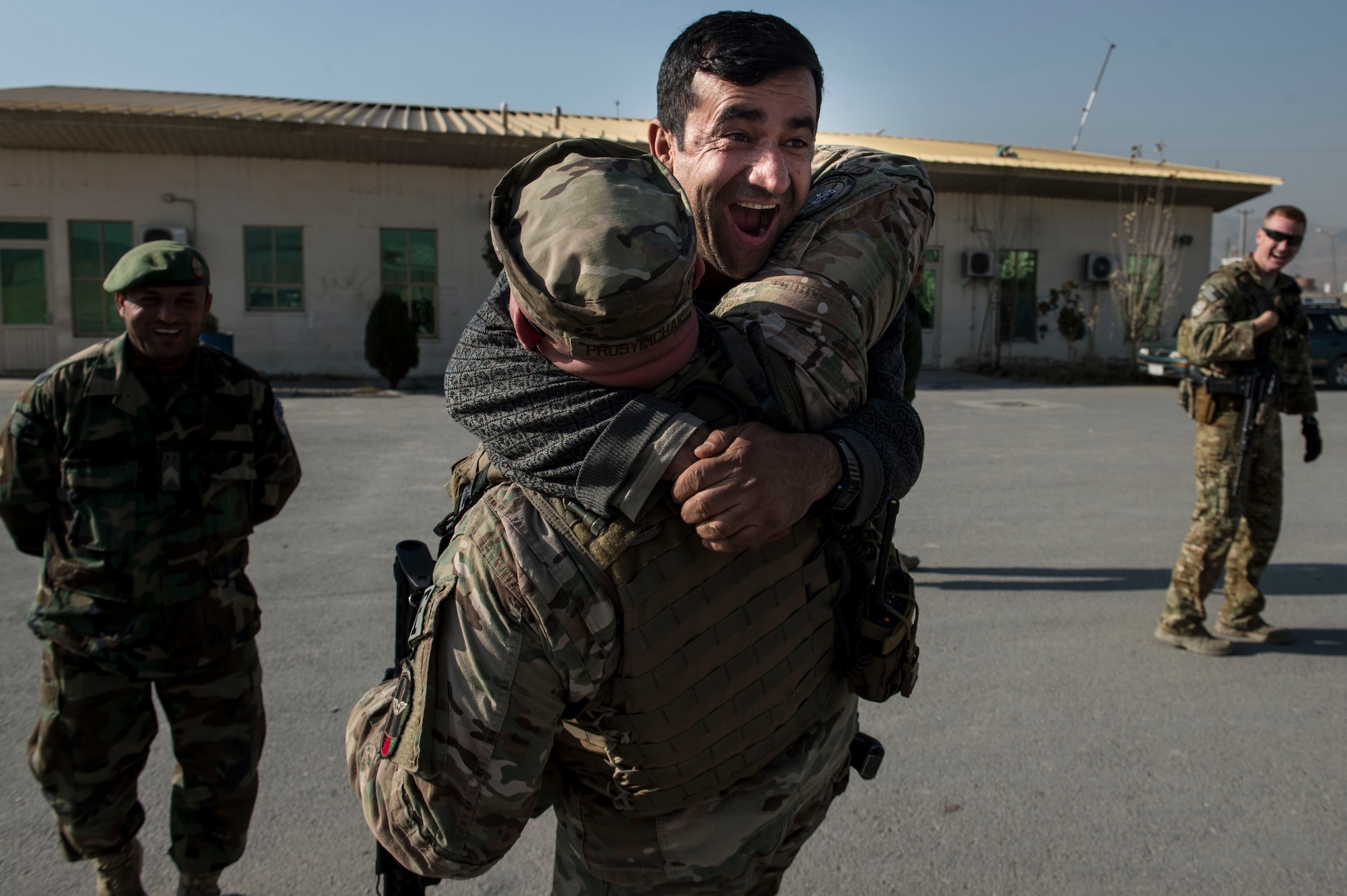 An Afghan Air Force soldier jumps into the arms of U.S Air Force Master Sgt. Daniel Prosymchak near Forward Operating Base Oqab, Kabul, Afghanistan, Dec. 13, 2015. Prosymchak is assigned to the Train, Advise, Assist Command-Air (TAAC-Air) security forces and is deployed from Charleston Air Force Base, S.C. (U.S. Air Force photo by Staff Sgt. Corey Hook/Released)
