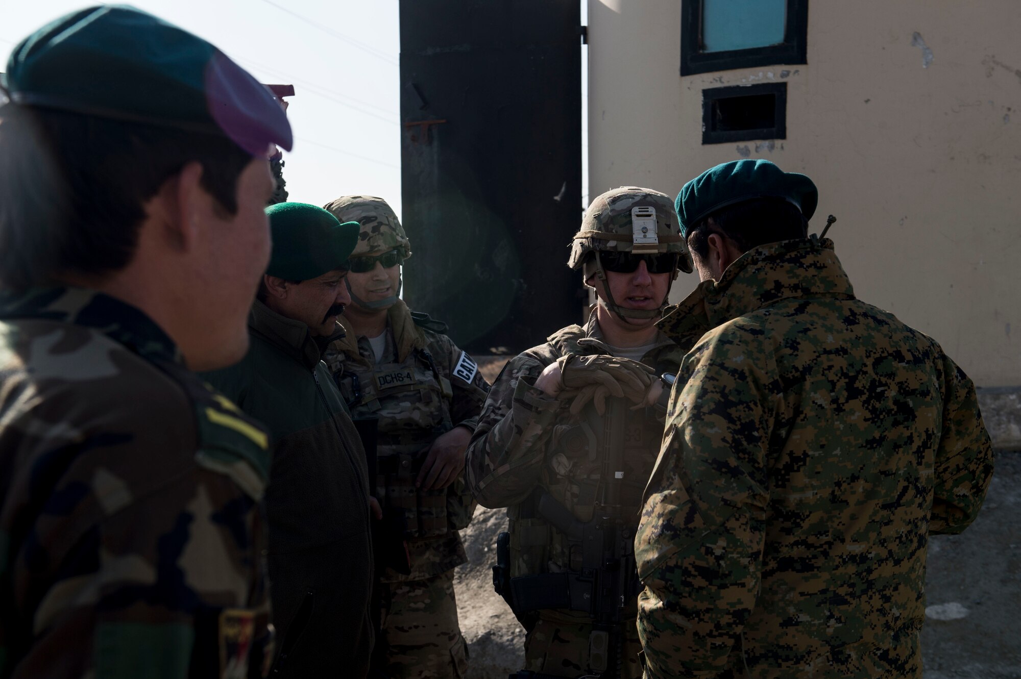 (Left) U.S Air Force Staff Sgt. Mark Saldana and Tech. Sgt. Beau Hanson visit with Afghan Air Force soldiers near Forward Operating Base Oqab, Kabul, Afghanistan, Dec. 13, 2015. Saldana and Hanson are assigned to Train, Advise, Assist Command-Air (TAAC-Air) security forces as advisors.  (U.S. Air Force photo by Staff Sgt. Corey Hook/Released)