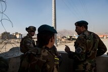 (Left) U.S Air Force Capt. Ryan Kiggins visits with Afghan Air Force soldiers near Forward Operating Base Oqab, Kabul, Afghanistan, Dec. 13, 2015. Kiggens is assigned to the Train, Advise, Assist Command-Air (TAAC-Air) security forces as an advisor. (U.S. Air Force photo by Staff Sgt. Corey Hook/Released) 