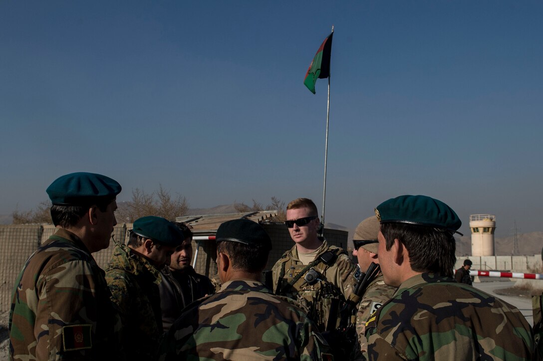 (Middle) U.S Air Force Capt. Ryan Kiggins visits with Afghan Air Force soldiers near Forward Operating Base Oqab, Kabul, Afghanistan, Dec. 13, 2015. Kiggens is assigned to the Train, Advise, Assist Command-Air (TAAC-Air) security forces as an advisor. (U.S. Air Force photo by Staff Sgt. Corey Hook/Released)