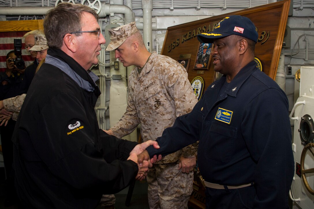 U.S. Defense Secretary Ash Carter, left, is greeted by U.S. Navy Capt. Augustus P. Bennett, commander, Amphibious Squadron 4, during his visit aboard the amphibious assault ship USS Kearsarge in the Arabian Gulf, Dec. 19, 2015. U.S. Navy photo by Petty Officer 3rd Class Tyler Preston