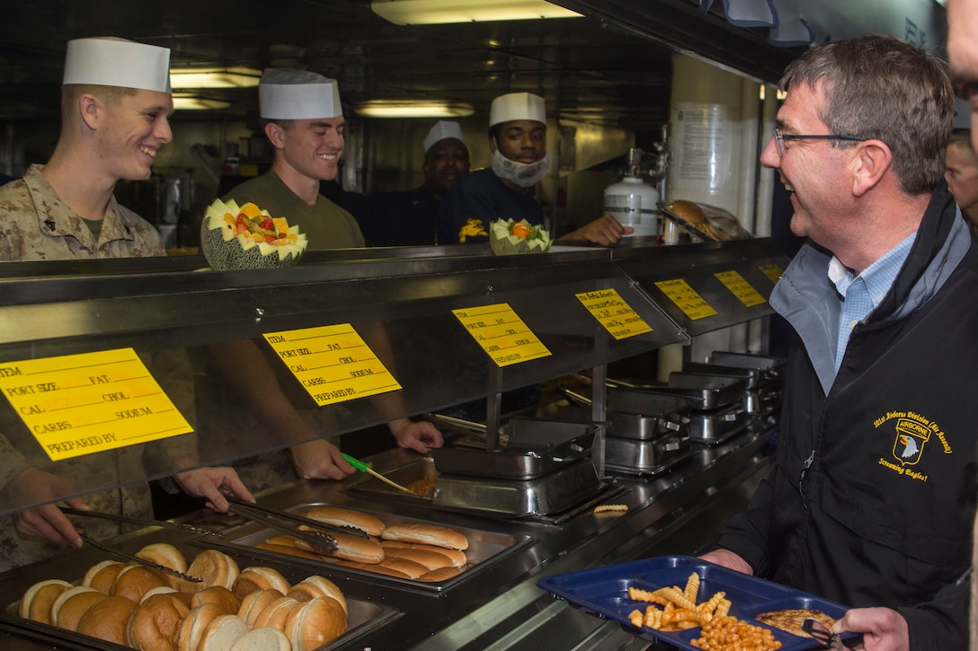 U.S. Defense Secretary Ash Carter speaks with sailors and Marines while going through the serving line during his visit aboard the amphibious assault ship USS Kearsarge in the Arabian Gulf, Dec. 19, 2015. U.S. Navy photo by Petty Officer 3rd Class Tyler Preston