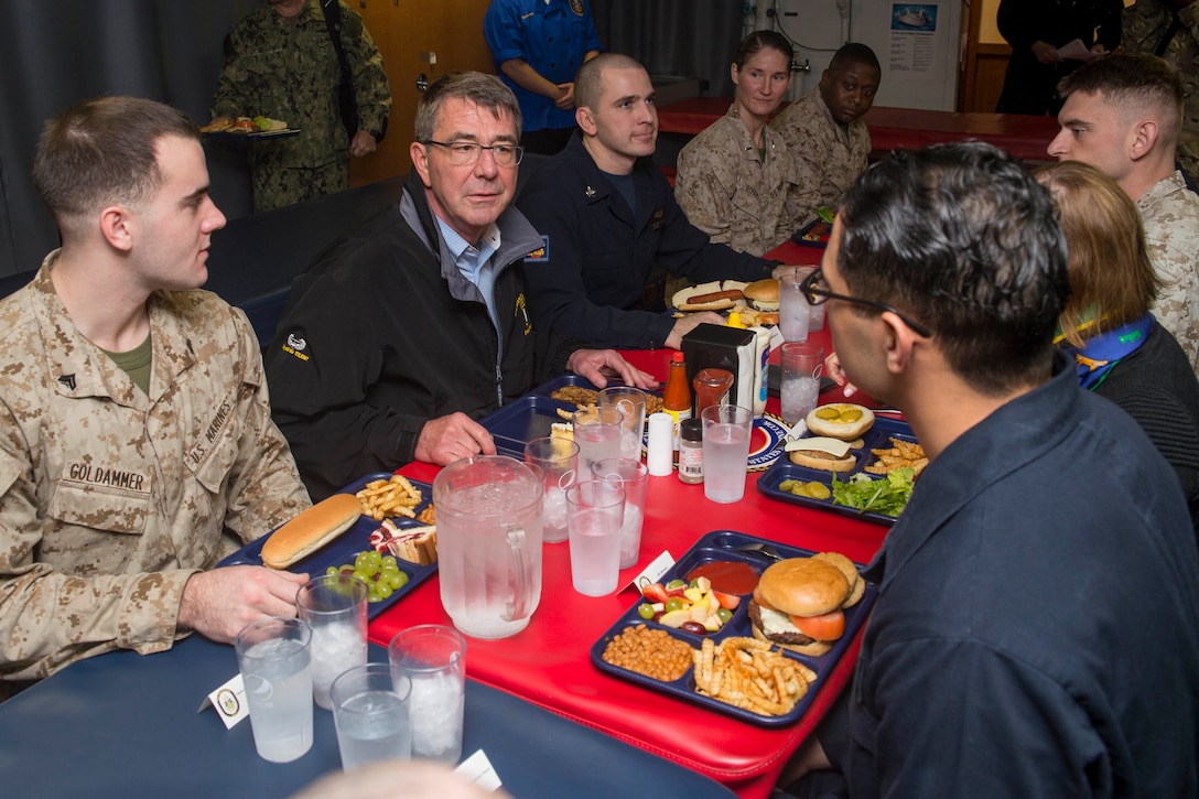 U.S. Defense Secretary Ash Carter speaks with sailors and Marines while having lunch with them during his visit aboard the amphibious assault ship USS Kearsarge in the Arabian Gulf, Dec. 19, 2015. U.S. Navy photo by Petty Officer 3rd Class Tyler Preston