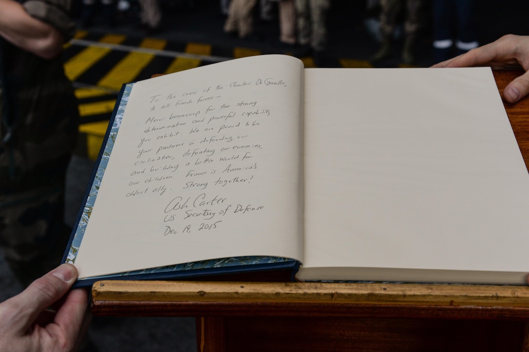 U.S. Defense Secretary Ash Carter signs the guest book aboard the flagship of the French Navy ship the Charles de Gaulle on Dec. 19, 2015. Carter is on a weeklong trip in which he is visiting leaders and deployed service members in the Middle East and Afghanistan. DoD photo by U.S. Army Sgt. 1st Class Clydell Kinchen