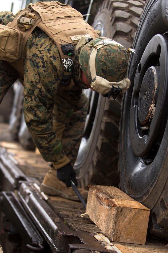 A U.S. Marine removes a wooden block before unloading heavy equipment at Bethesda rail station in Romania, Dec. 6, 2015. U.S. Marine Corps photo by Lance Cpl. Melanye E. Martinez