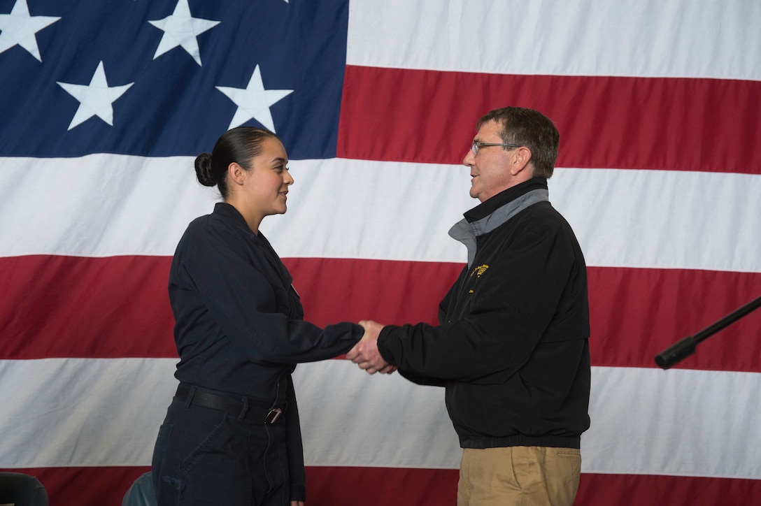 U.S. Defense Secretary Ash Carter congratulates U.S. Navy Seaman Alexandra Leon on her selection as Kearsarge's 2015 Blue Jacket of the Year selectee, during his visit aboard the amphibious assault ship USS Kearsarge in the Arabian Gulf, Dec. 19, 2015. Leon is an aviation maintenance administrationman airman. U.S. Navy photo by Petty Officer 3rd Class Tyler Preston