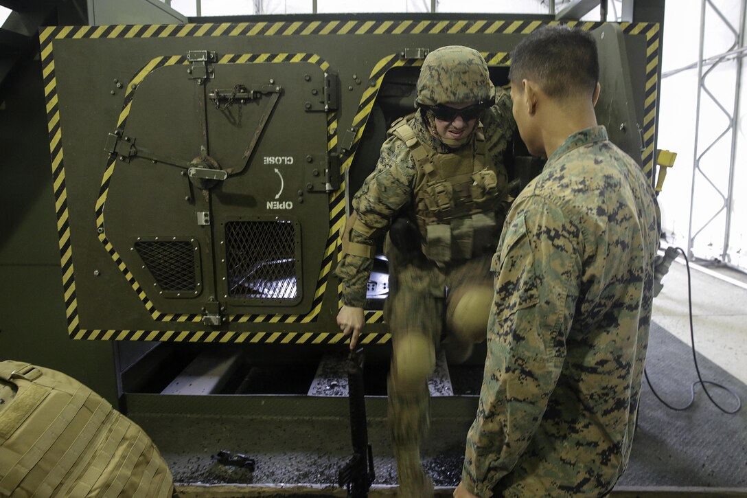 A Marine with 2nd Supply Battalion, 2nd Marine Logistics Group climbs out of a Humvee Egress Assistance Trainer simulator during a class at Marine Corps Base Camp Lejeune, N.C., Dec. 17, 2015. The HEAT class is designed to show Marines what to do if a vehicle rolls over during low visibility, no visibility, or experiences sideways or 180-degree rollovers. 