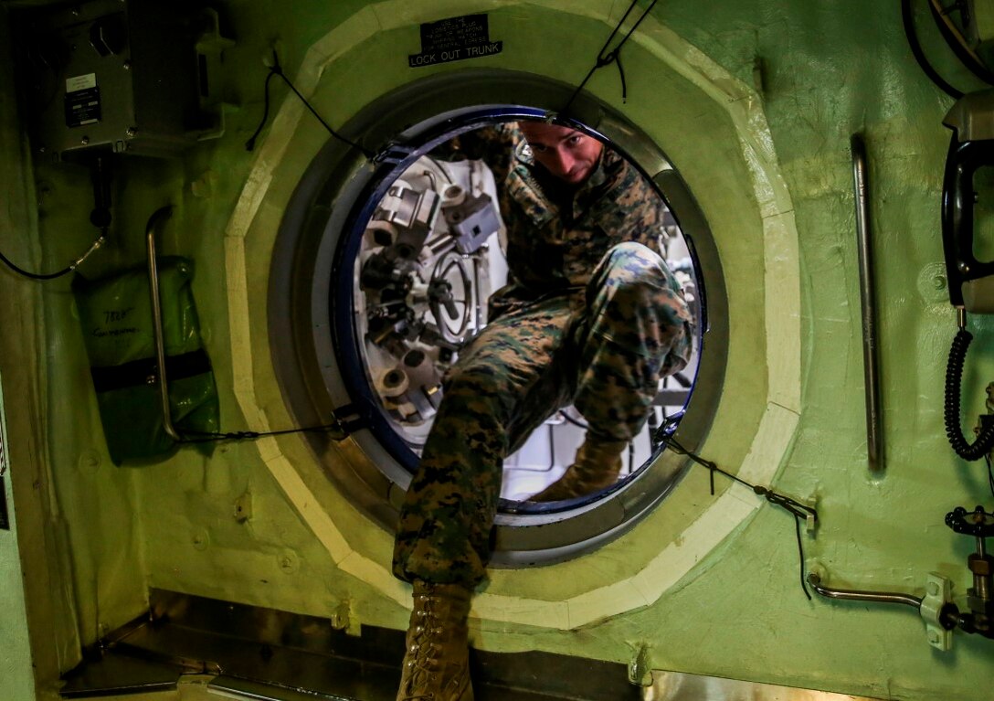 Capt. Morgan Jordan, from Dallas, and 1st Platoon Commander with Company A, 1st Reconnaissance Battalion, 1st Marine Division, climbs out of the lock-out trunk on the USS Mississippi, a Virginia Class Block 5 submarine aboard Joint Base Pearl Harbor-Hickam, Hawaii, Nov. 17, 2015. Company A toured the ship as part of a one-day Special Operations Forces capabilities training event, where they learned about lock-out submarine insertions. (U.S. Marine Corps Photo by Sgt. Tony Simmons)
