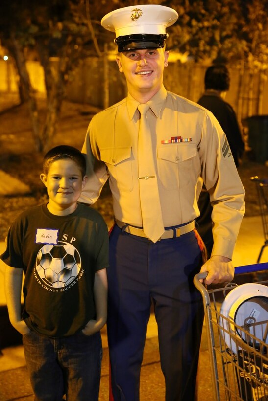 Kaden Jeide (left) and Cpl. Matthew Franzoni, pose for a picture after spending the night shopping for Christmas presents as part of a “holiday with Heroes” event held in Poway, California, December 10. During the city-funded event, children purchased presents for their families and friends, took holiday photos with Santa, built arts and crafts, and participated in other events throughout the Night. (USMC photo by Cpl. Jonathan Boynes)