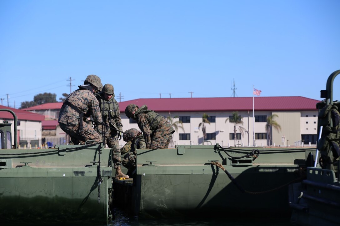 Marines from Bridge Company, 7th Engineer Support Battalion, Combat Logistics Regiment 1, 1st Marine Logistics Group connect couplings from two Mark III improved ribbon bridges across a body of water. The battalion trained in tandem with Marines from 6th ESB out of Battle Creek, Mich., aboard Marine Corps Base Camp Pendleton, Dec. 12, 2015. The IRB is a more improved version of the original and is used to move personnel and tactical vehicles over non-passable waterways.