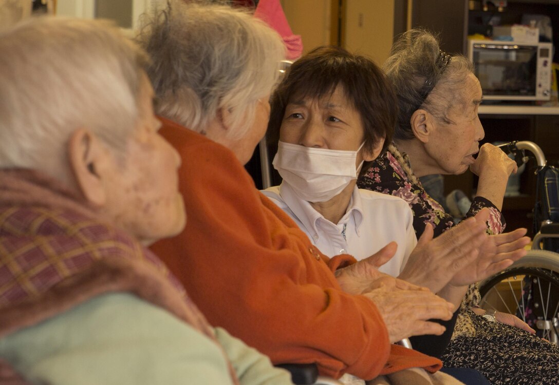 Residents of the Vita Nursing Home in Iwakuni, Japan, give applause toward the station volunteers from Marine Corps Air Station Iwakuni Dec. 16, 2015. The chapel coordinated this community even as an opportunity to experience Japanese culture, give back to the local community and strengthen the bond between the U.S. and Japan. Volunteers sang Christmas carols, provided baked goods and gifts and provided residents with a sense of holiday spirit.
