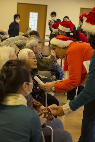 Volunteers from Marine Corps Air Station Iwakuni, Japan, wish residents at the Vita Nursing Home in Iwakuni, a merry Christmas after caroling on Dec. 16, 2015. The chapel coordinated this community even as an opportunity to experience Japanese culture, give back to the local community and strengthen the bond between the U.S. and Japan. Nursing home residents expressed happiness, appreciation and shed tears of joy toward the residents.