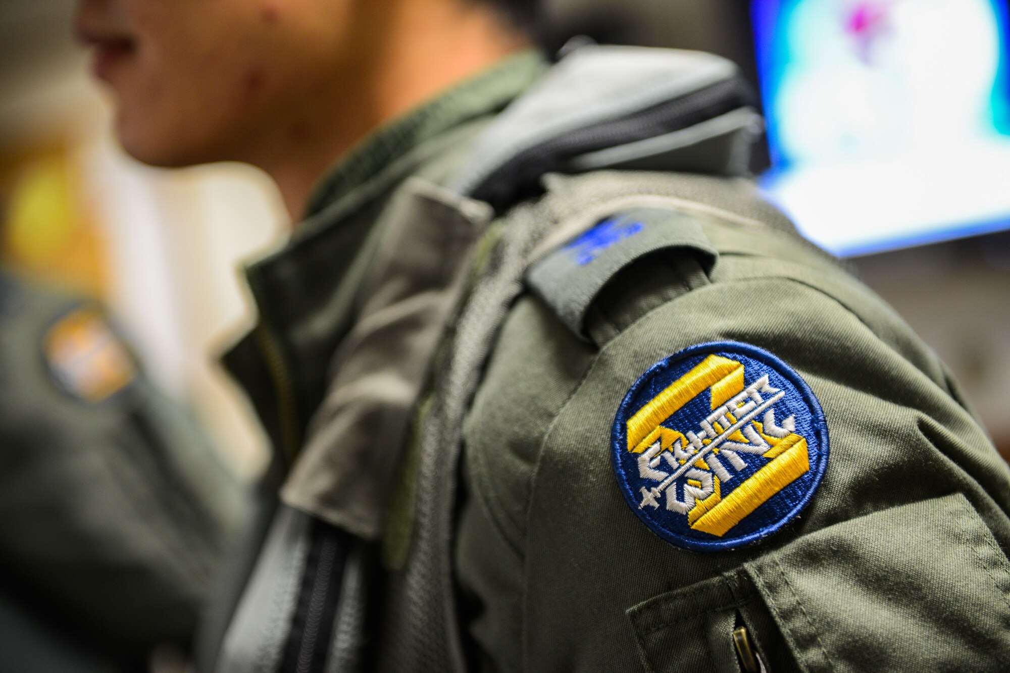 A Republic of Korea air force 8th Fighter Wing is affixed on the shoulder on a ROKAF pilot during Buddy Wing 15-8 at Osan Air Base, ROK, Dec. 17, 2015. ROKAF pilots integrated with 25th Fighter Squadron pilots to train on forward air control and close air support missions. (U.S. Air Force photo/Airman 1st Class Dillian Bamman)