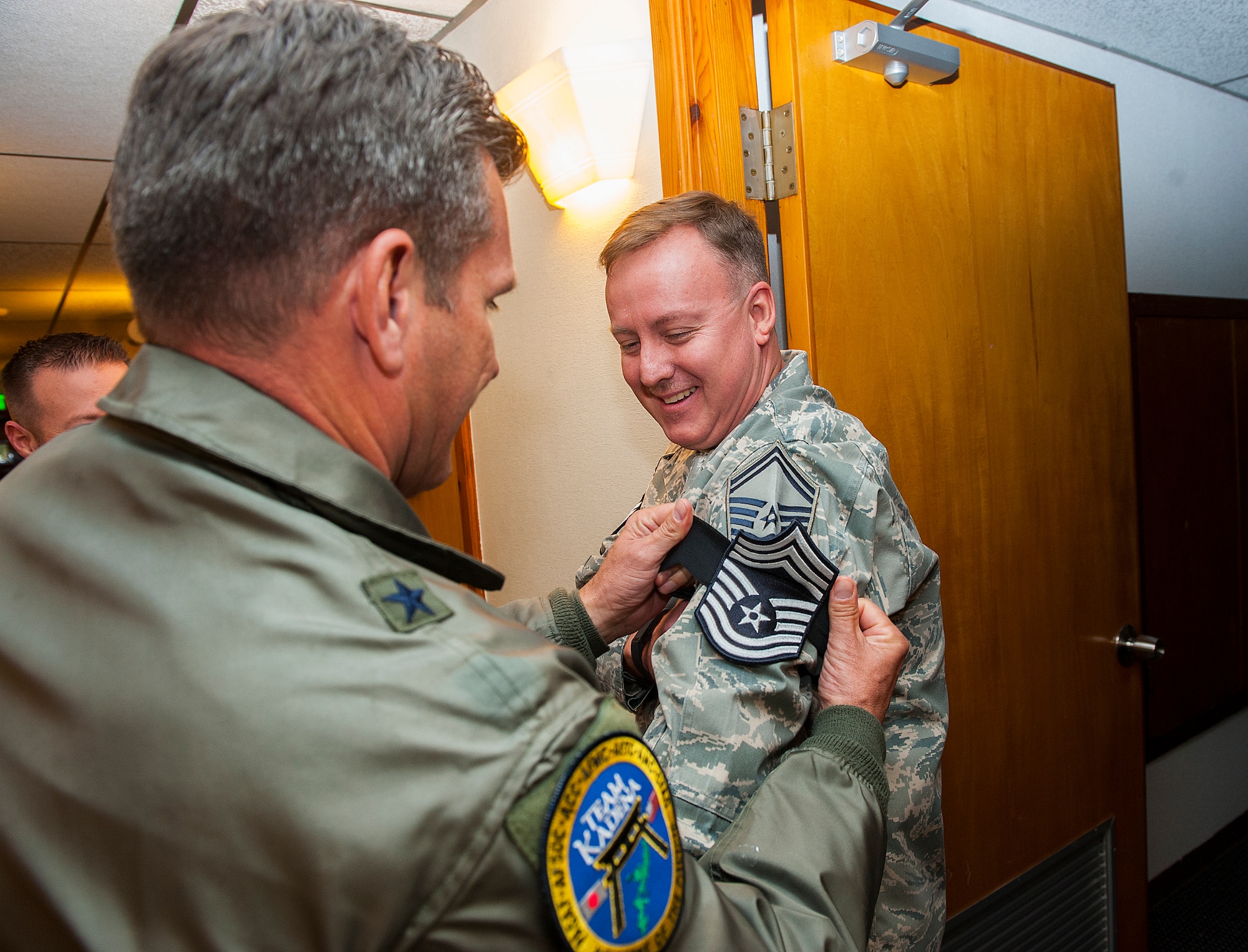 U.S. Air Force Brig. Gen. Barry Cornish, 18th Wing commander, puts chief master sergeant stripes on Senior Master Sgt. David Braun, 18th Wing executive administration superintendent, Dec. 17, 2015, at Kadena Air Base, Japan. Eight senior master sergeants here were selected to be promoted to the ranks of chief master sergeant. (U.S. Air Force photo by Airman 1st Class Corey M. Pettis)