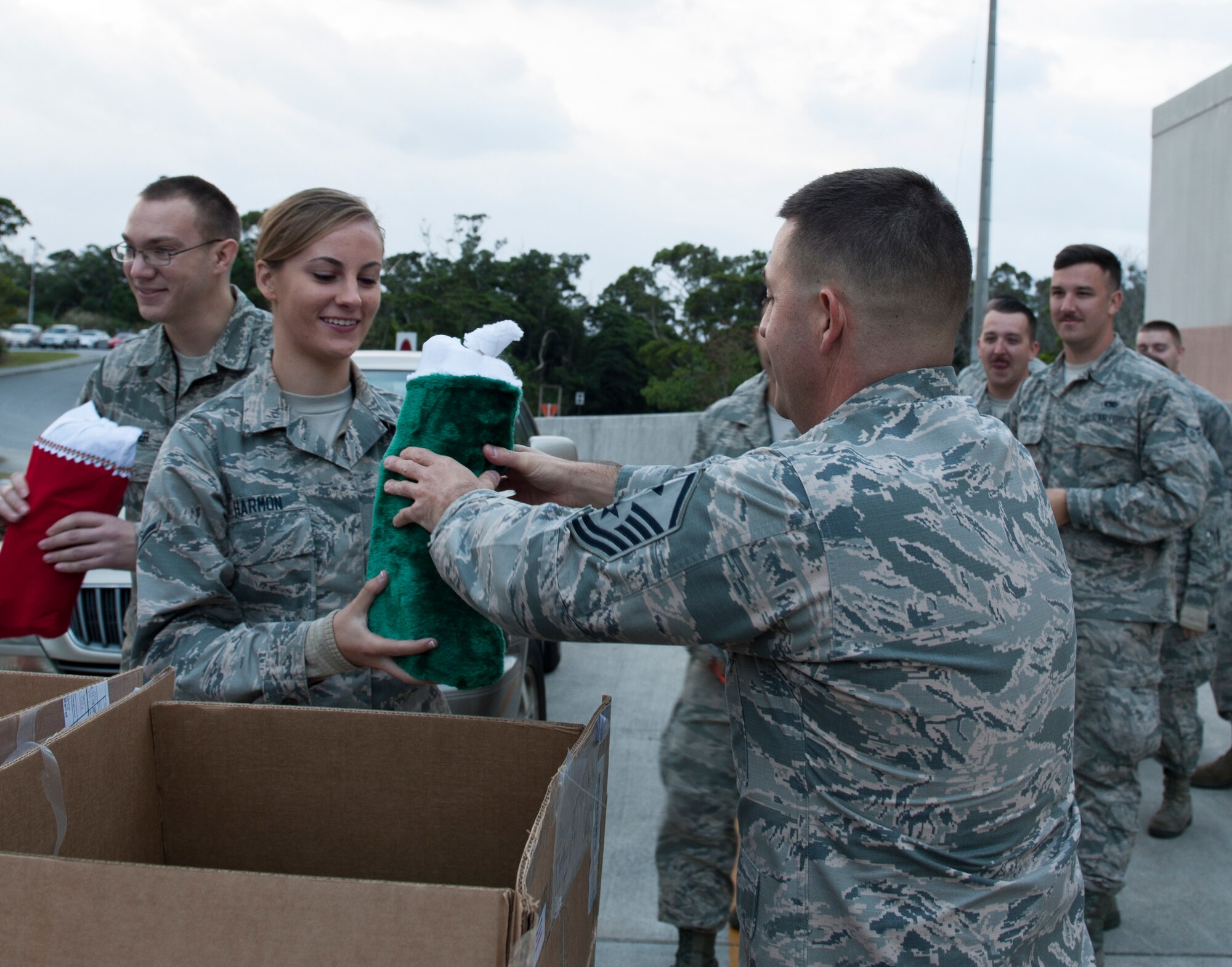 U.S. Air Force Master Sgt. Justin Stoltzfus, 18th Munitions Squadron first sergeant, delivers a Christmas stocking to Airman Erin Harmon, 18th Munitions Squadron conventional maintenance crew member, Dec. 17, 2015, at Kadena Air Base, Japan. Chief Master Sgt. Patrick VanVranken, 18th MUNS superintendent, delivered stockings to MUNS members as a courtesy of Boatsie’s Boxes Inc., an organization dedicated to serving the United States Armed Forces. (U.S. Air Force photo by Airman 1st Class Lynette M. Rolen)