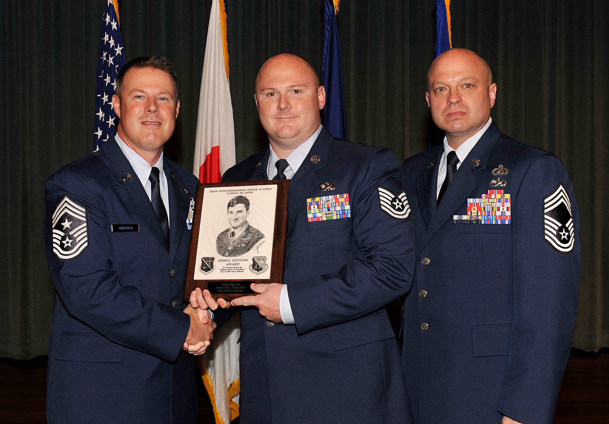 U.S. Air Force Tech. Sgt. Joseph Beckham, 730th Air Mobility Squadron at Yokota Air Base, Japan, receives the John L. Levitow Award during the NCO Academy Class 16-1 graduation ceremony at the Keystone Theater, Dec. 18, 2015, at Kadena Air Base, Japan. This award, named in memory of Medal of Honor recipient Airman 1st Class John L. Levitow, is presented to members of professional military education classes who exhibit superior achievement as leaders and scholars. (U.S. Air Force photo by Naoto Anazawa)