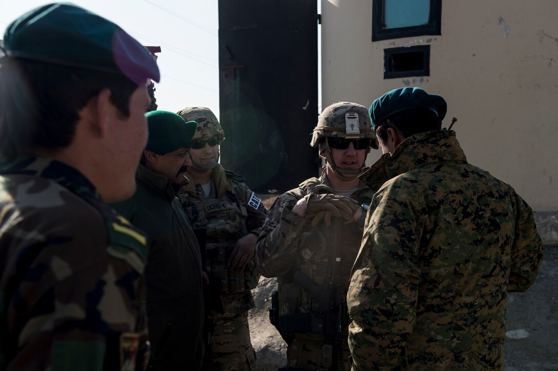 U.S. Air Force Tech. Sgts. Mark Saldana, center left, and Beau Hanson, center right, visit with Afghan airmen near Forward Operating Base Oqab in Kabul, Afghanistan, Dec. 13, 2015. Saldana and Hanson are assigned to Train, Advise, Assist Command's air security forces as advisors. U.S. Air Force photo by Staff Sgt. Corey Hook