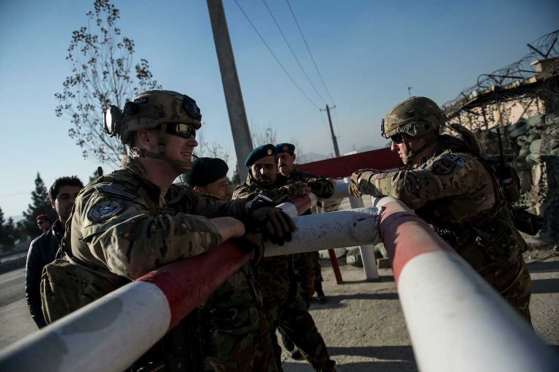 U.S. Air Force Capt. Ryan Kiggins, left, and Tech. Sgt. Beau Hanson visit with Afghan airmen near Forward Operating Base Oqab in Kabul, Afghanistan, Dec. 13, 2015. U.S. Air Force photo by Staff Sgt. Corey Hook