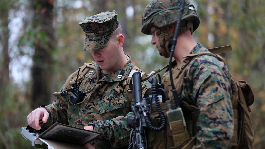 (Left) Captain Jerald Feehery, a project officer for Marine Corps Warfighting Laboratory, discusses tactics with Capt. Patrick Parks, the Lima Company commander with 3rd Battalion, 6th Marine Regiment, prior to entering the Military Operation in Urban Terrain during a limited objective experiment at Marine Corps Base Lejeune, N.C., Dec. 8, 2015. The Marine Corps Warfighting Laboratory worked with 3rd Bn., 6th Marines, and 1st Battalion, 10th Marine Regiment, to test artillery and infantry integration tactics. During the experiment, the company landing team attacked from near the Onslow Beach landing site towards the objective of the Military Operation in Urban Terrain training center.