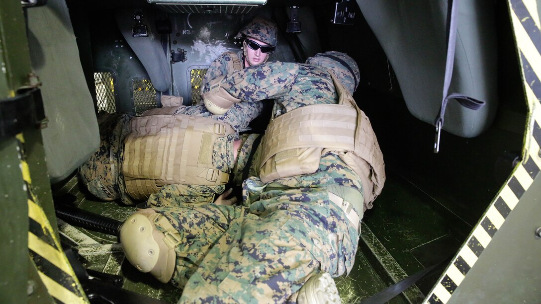 Marines with 2nd Supply Battalion, 2nd Marine Logistics Group rehearses life-saving techniques on a fellow Marine during a Humvee Egress Assistance Trainer class at Marine Corps Base Camp Lejeune, N.C., Dec. 17, 2015.  The HEAT class is designed to show Marines what to do if a vehicle rolls over during low visibility, no visibility, or experiences sideways or 180-degree rollovers.  