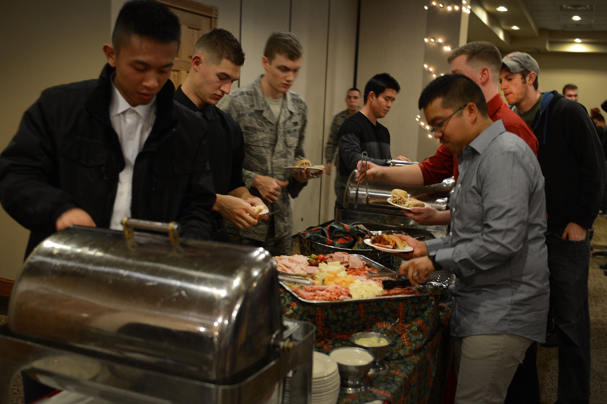 Cannon Airmen load their plates with food during the Single Airmen Christmas party Dec. 16, 2015, at Cannon Air Force Base, N.M. The annual event is sponsored courtesy of nearby Clovis and the Committee of Fifty, a local organization that supports Cannon and its Air Commandos. (U.S. Air Force photo/Staff Sgt. Matthew Plew)