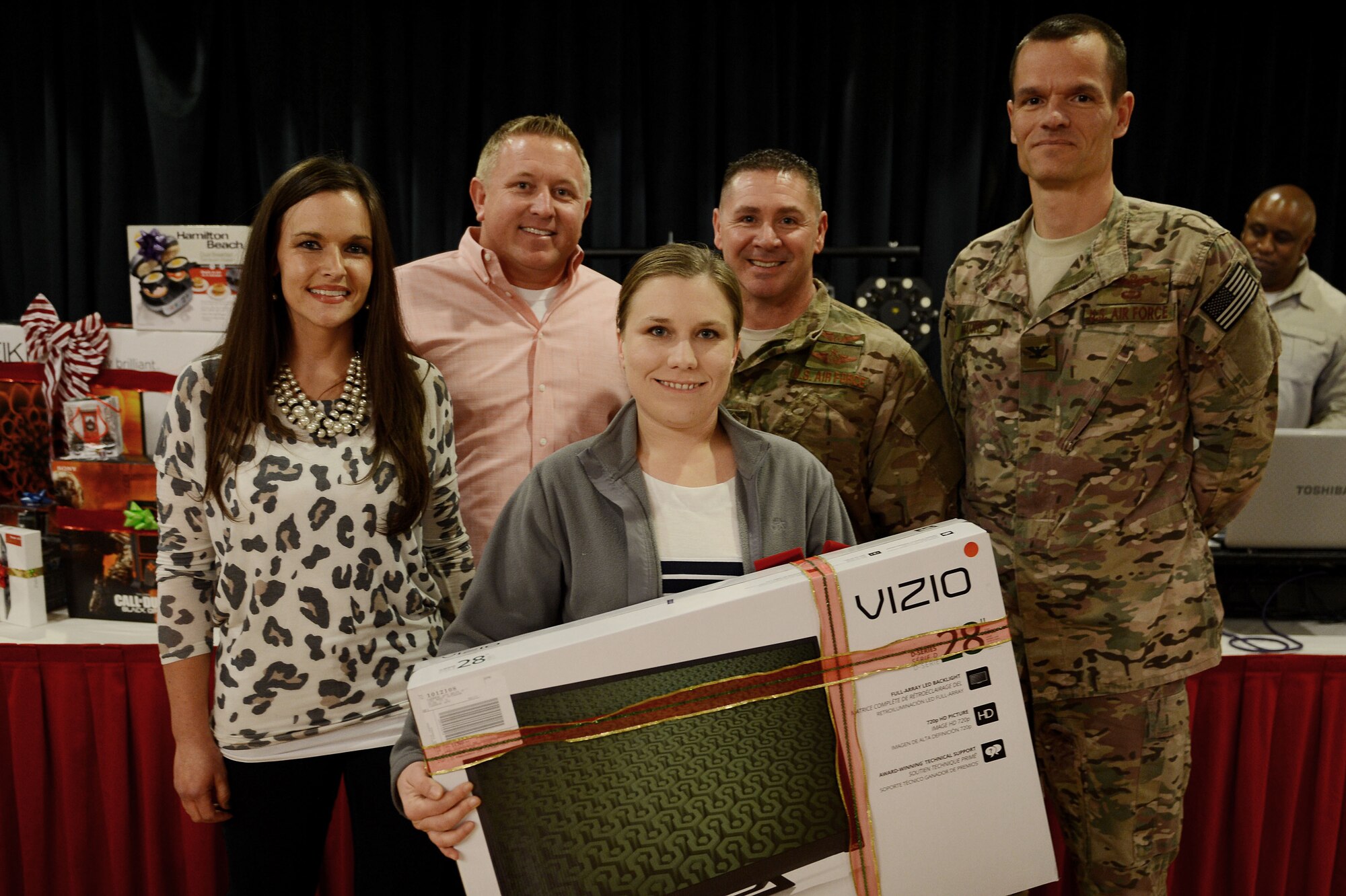 U.S. Air Force Senior Airman Sarah Filbin, 27th Special Operations Aerospace Medicine Squadron, wins a 28” television set during the Single Airmen Christmas party Dec. 16, 2015, at Cannon Air Force Base, N.M. Filbin posed for a photo with Clovis Committee of Fifty members Sarah and Justin Stagner, Chief Master Sgt. Randy Scanlan, 27th Special Operations Wing command chief, and Col. Ben Maitre, 27th SOW commander, after her winning ticket was drawn. (U.S. Air Force photo/Staff Sgt. Matthew Plew)