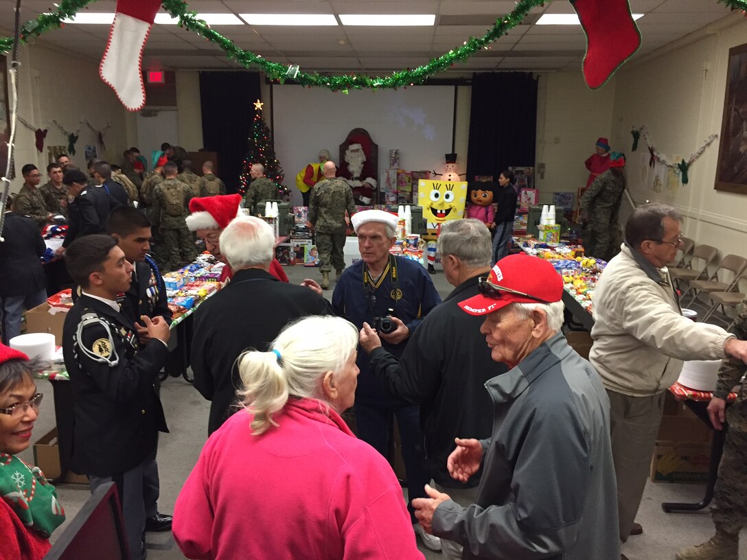 Marines and family members of Alpha Company, Marine Corps Communication Electronic School are treated to holiday festivities by the Four Seasons Retirement Community and the Soboba Indian Tribe from Hemet, CA.  The Marines received free food, knitted hats, and playing cards while the children were presented toys from Santa Claus and had their faces painted during this annual event.
