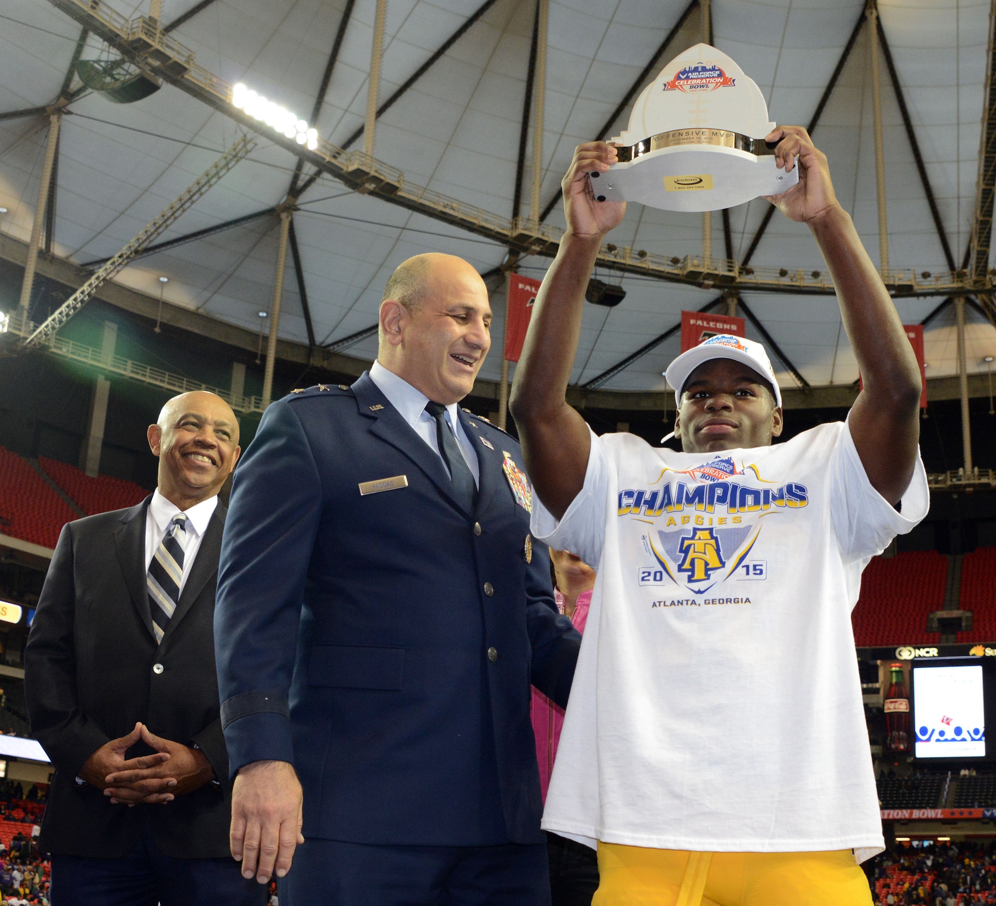 Maj Gen Richard S. Haddad hands out the offensive MVP award to North Carolina A&T's Tarik Cohen  who rushed for 295 touchdowns and three touchdowns of 73 or more yards Saturday. North Carolina A&T won the thriller 41-34 over Alcorn State in the Air Force Reserve Celebration Bowl at the Georgia Dome. (Air Force photo/Master Sgt. Chance Babin)