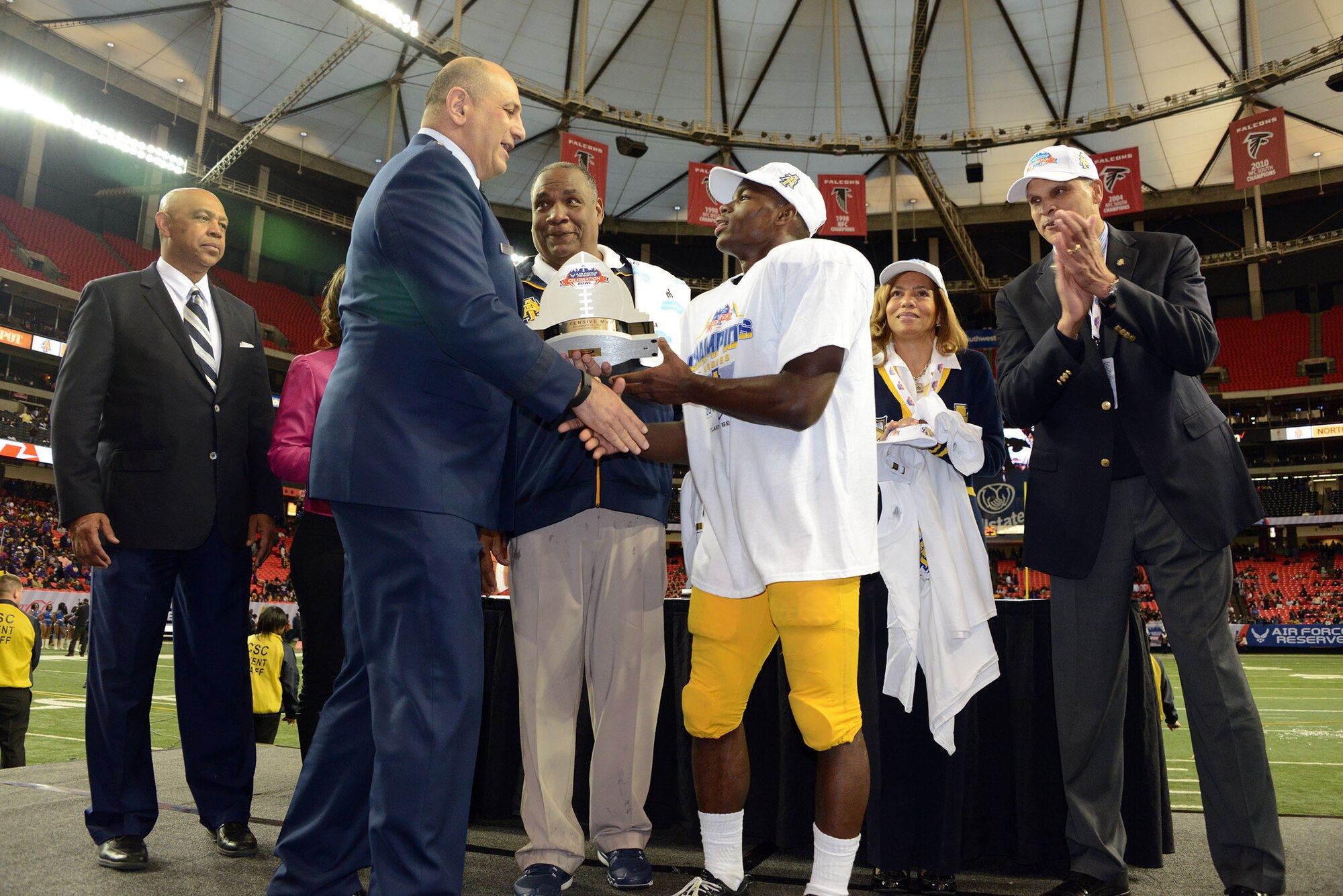 Maj Gen Richard S. Haddad hands out the offensive MVP award to North Carolina A&T's Tarik Cohen  who rushed for 295 touchdowns and three touchdowns of 73 or more yards Saturday. North Carolina A&T won the thriller 41-34 over Alcorn State in the Air Force Reserve Celebration Bowl at the Georgia Dome. (Air Force photo/Master Sgt. Chance Babin)