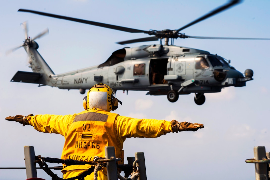 U.S. Navy Petty Officer 3rd Class B. Duncan signals an MH-60S Seahawk helicopter aboard the USS Gonzalez in the Gulf of Aden, Dec. 18, 2015. The Gonzalez is deployed as part of the Harry S. Truman Carrier Strike Group, supporting maritime security operations and theater security cooperation efforts in the U.S. 5th Fleet area of responsibility. U.S. Navy photo by Petty Officer 3rd Class P. Sena