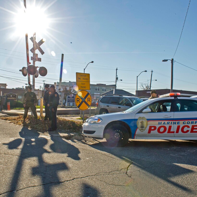 Military police and civilian law enforcement officers with Security Battalion, Marine Corps Base Quantico, check the identification of people who enter the base from the Virginia Railway Express station in the Town of Quantico. Security Battalion Marines routinely conduct random ID checks on people who ride the VRE trains and access the base through the Town of Quantico. In an effort to increase the security of the base and the safety of the people who work aboard the base, Security Battalion Marines maintain increased awareness at base access points. (Released/ Photo by Lance Cpl. Elisha Peake)