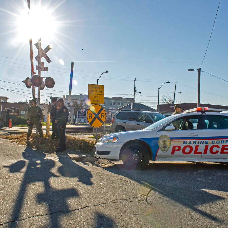 Military police and civilian law enforcement officers with Security Battalion, Marine Corps Base Quantico, check the identification of people who enter the base from the Virginia Railway Express station in the Town of Quantico. Security Battalion Marines routinely conduct random ID checks on people who ride the VRE trains and access the base through the Town of Quantico. In an effort to increase the security of the base and the safety of the people who work aboard the base, Security Battalion Marines maintain increased awareness at base access points. (Released/ Photo by Lance Cpl. Elisha Peake)