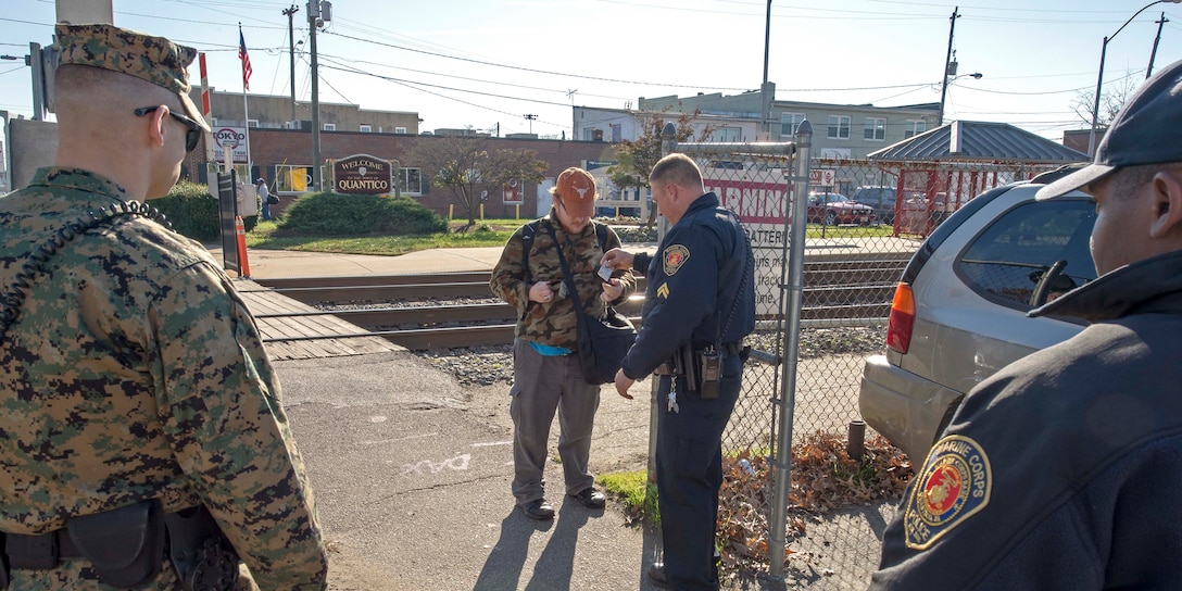 Military police and civilian law enforcement officers with Security Battalion, Marine Corps Base Quantico, check the identification of people who enter the base from the Virginia Railway Express station in the Town of Quantico. Security Battalion Marines routinely conduct random ID checks on people who ride the VRE trains and access the base through the Town of Quantico. In an effort to increase the security of the base and the safety of the people who work aboard the base, Security Battalion Marines maintain increased awareness at base access points.