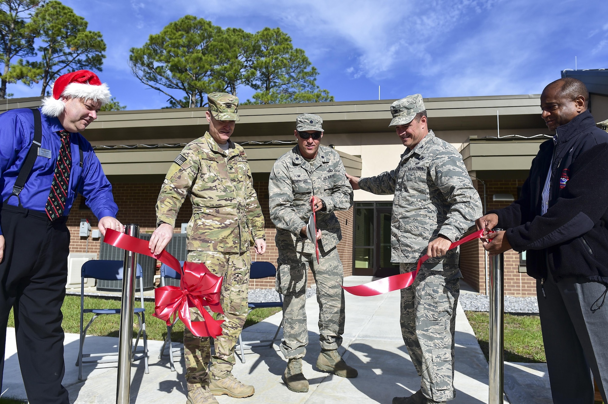 Col. Sean Farrell, commander of the 1st Special Operations Wing, and Col. Todd Fogle, commander of the 1st Special Operations Mission Support Group, assist Lt. Col. Lee Comerford, commander of the 1st Special Operations Force Support Squadron, in cutting the ribbon for the new temporary lodging facility (TLF) at Hurlburt Field, Fla., Dec. 18, 2015. The new two bedroom TLF began construction in June, 2014, and set improving the living quarters for Airmen and their families’ transitioning to and from Hurlburt in motion, as well as meeting the shortage of TLF units. (U.S. Air Force photo by Senior Airman Jeff Parkinson)