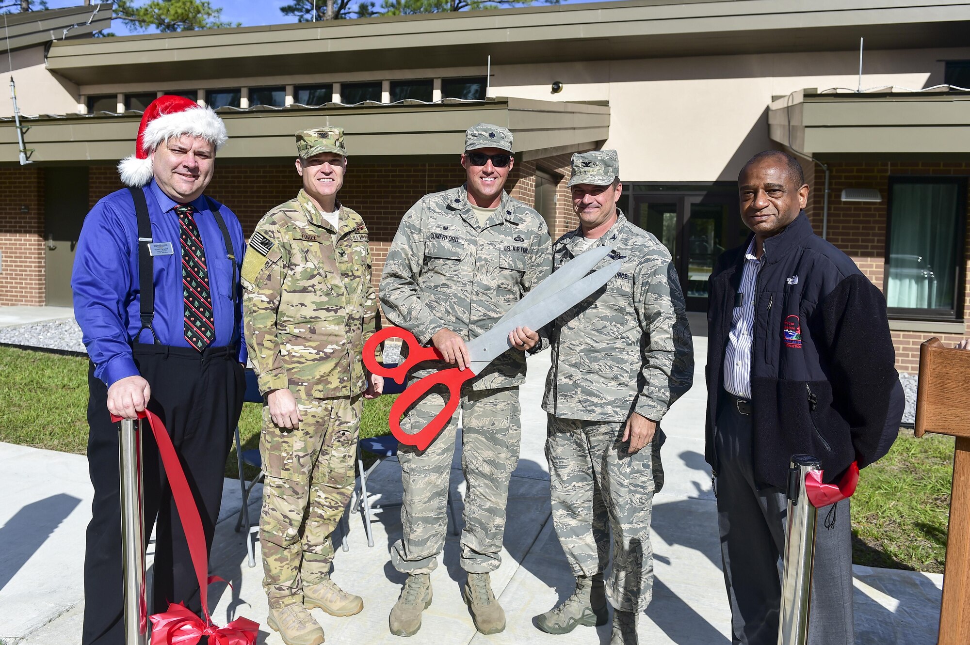 Air Commandos celebrate the opening of the new temporary lodging facility (TLF) at Hurlburt Field, Fla., Dec. 18, 2015. The new TLF offers eight two bedroom units to provide space for larger families transitioning to and from Hurlburt Field. (U.S. Air Force photo by Senior Airman Jeff Parkinson)