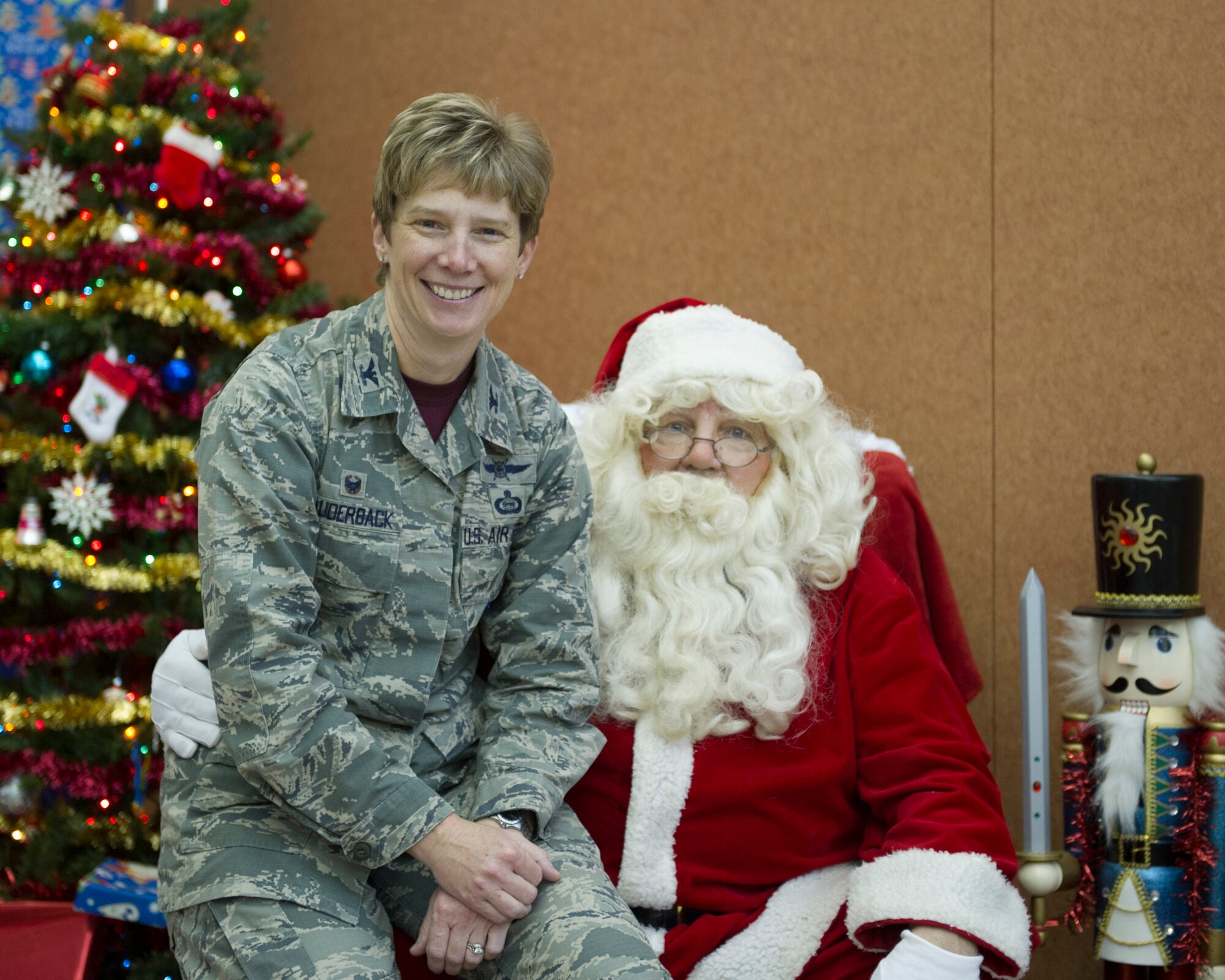 U.S. Air Force Col. Leah Lauderback, National Air and Space Intelligence Center Commander, sits on Santa's lap during the Center’s open house at Wright-Patterson Air Force Base, Ohio, Dec. 11, 2015. The NASIC staff welcomed more than 800 family members during the annual event. (U.S. Air Force Photo by Senior Airman Justyn M. Freeman)  