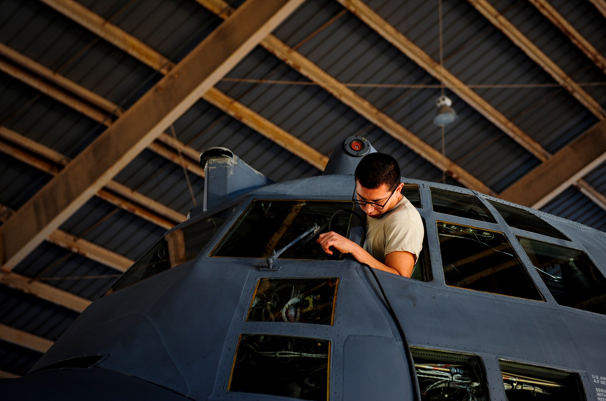 Senior Airman Fernando Cardenas, a crew chief with the 1st Special Operations Aircraft Maintenance Squadron, pulls a communications line into an AC-130U Spooky Gunship during routine maintenance at Hurlburt Field, Fla., Dec. 15, 2015. Crew chiefs with the 4th Aircraft Maintenance Unit are trained to diagnose malfunctions on the AC-130U Spooky Gunship during pre-flight and post-flight inspections, repair and refuel the aircraft, keep detailed records, marshal aircraft, to remain mission ready at all times.(U.S. Air Force photo by Senior Airman Meagan Schutter)