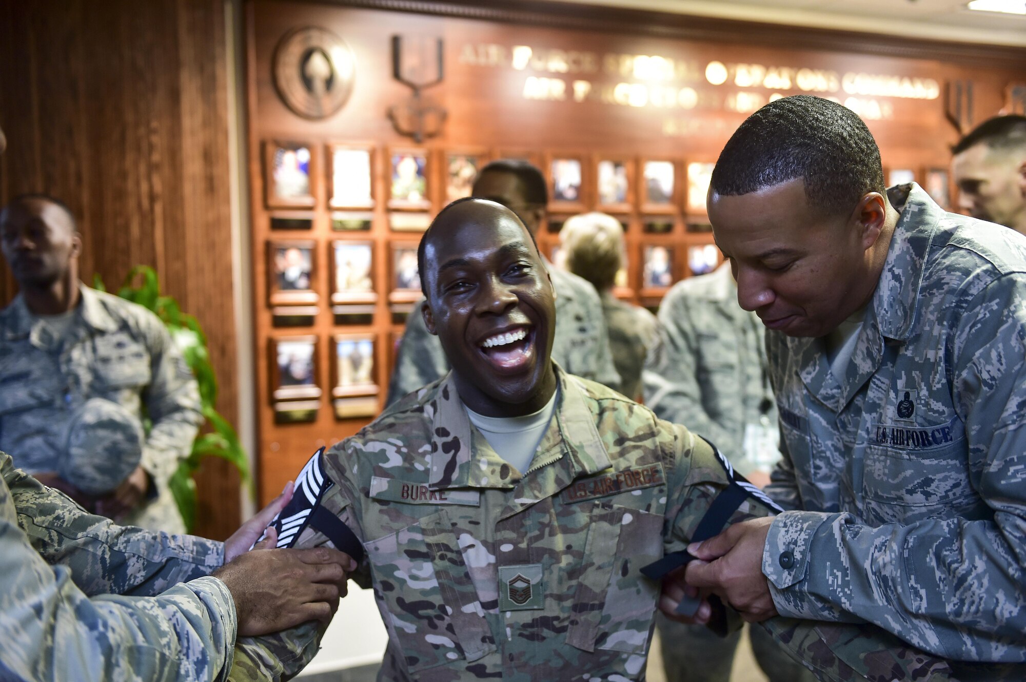 Senior Master Sgt. Leroy Burke III, 3A1 administration and personnel functional manager for Air Force Special Operations Command, pins on chief master sergeant at Hurlburt Field, Fla., Dec. 17, 2015. Chief master sergeants from Hurlburt traveled around base to congratulate all the new chief master sergeant selects. (U.S. Air Force photo by Senior Airman Jeff Parkinson)