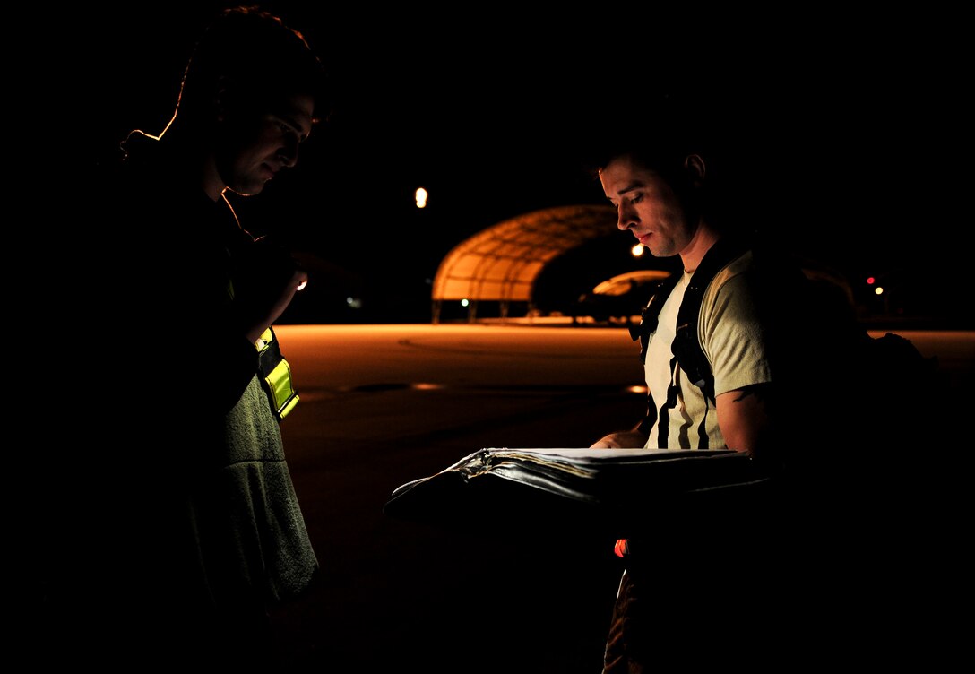 Senior Airman Corey Southerland and Airman 1st Class Nolan Davis, crew chiefs with the 1st Special Operations Aircraft Maintenance Squadron, check aircraft forms for discrepancies during routine maintenance at Hurlburt Field, Fla., Dec. 15, 2015. Crew chiefs with the 4th Aircraft Maintenance Unit are trained to diagnose malfunctions on the AC-130U Spooky Gunship during pre-flight and post-flight inspections, repair and refuel the aircraft, keep detailed records, marshal aircraft, to remain mission ready at all times. (U.S. Air Force photo by Senior Airman Meagan Schutter)