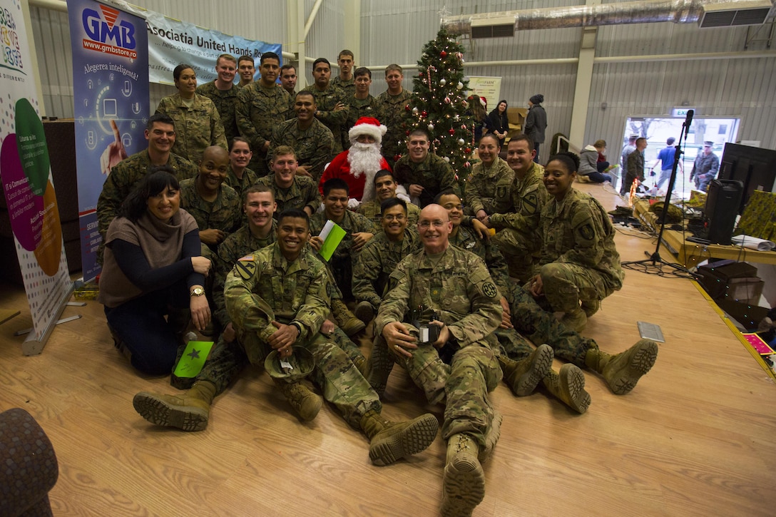 U.S. service members pose for a photo during a holiday party on Mihail Kogalniceanu Air Base, Romania, Dec. 19, 2015. Marine Corps photo by Lance Cpl. Melanye E. Martinez