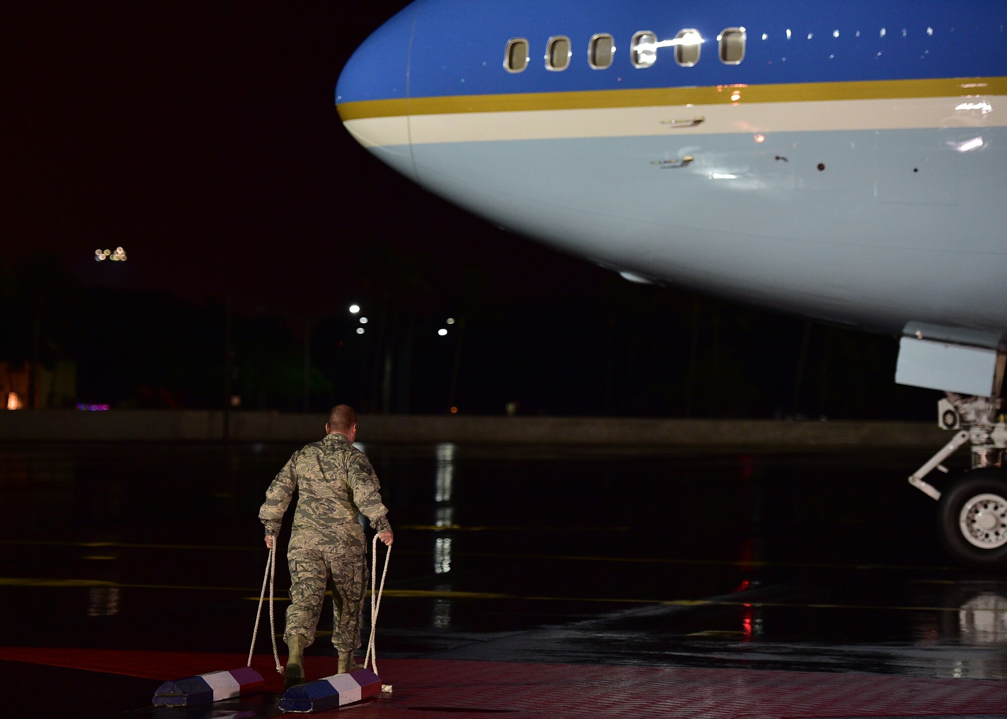 Staff Sgt. Joseph Stamps, from 15th Maintenance Squadron, walks toward Air Force one to chock the front landing gear as the ceremonial chocker on Joint Base Pearl Harbor-Hickam, Hawaii, Dec. 18 2015. The First Family passed through JBPHH as they begin their annual holiday vacation.  Airmen from the 15th Wing assisted with planning and preparation of the First Family’s arrival. (U.S. Air Force photo by Tech. Sgt. Aaron Oelrich/Released)