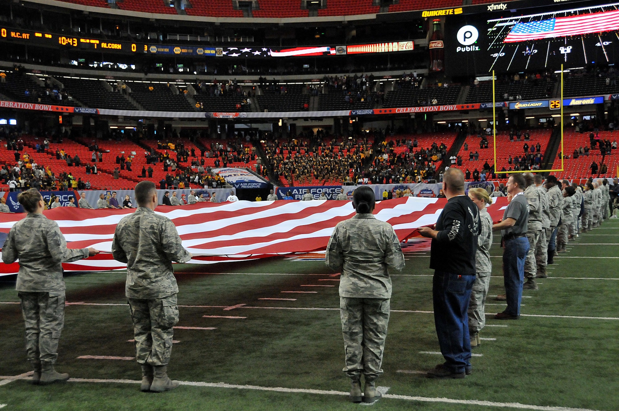 Airmen and a few family members unfurl the flag at the inaugural Air Force Reserve Celebration Bowl Dec. 19 at the Georgia Dome in Atlanta. It took nearly 60 people to unfurl the massive flag. (U.S. Air Force photo/Senior Airman Andrew Park)