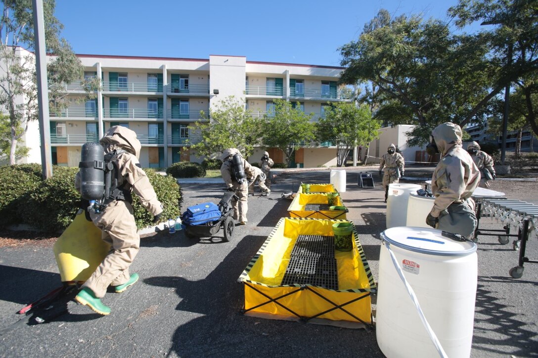 Marines pass the decontamination line to enter a building contaminated with black mold at Marine Corps Base Camp Pendleton, Calif., Dec. 17.  Once inside, the Marines identified other potentially dangerous substances as part of Chemical, Biological, Radioactive and Nuclear Assessment and Consequence Management training. The training included CBRN defense specialists and other Marines from Headquarters Regiment, 1st Marine Logistics Group, I Marine Expeditionary Force, who learned how to perform decontamination procedures. (U.S. Marine Corps photo by Lance Cpl. Caitlin Bevel).