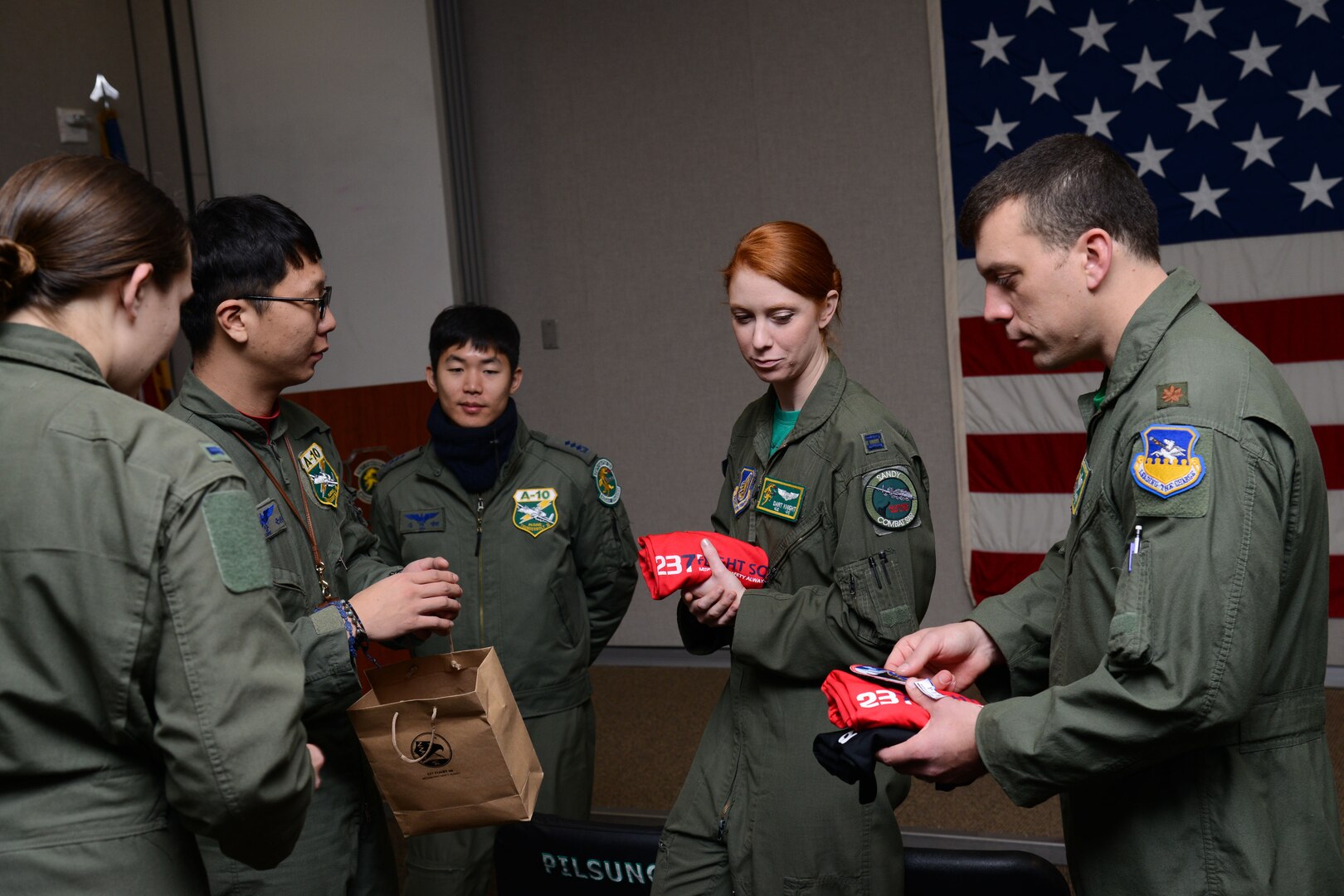 151218-F-LM669-009 OSAN AIR BASE, Republic of Korea (Dec. 17, 2015) U.S. Air Force and Republic of Korea air force pilots exchange squadron gifts during Buddy Wing 15-8 at Osan Air Base, ROK, Dec. 18, 2015. The pilots exchanged their squadron’s patches and t-shirts before the ROKAF pilots depart Osan. (U.S. Air Force photo by Airman 1st Class Dillian Bamman/Released)