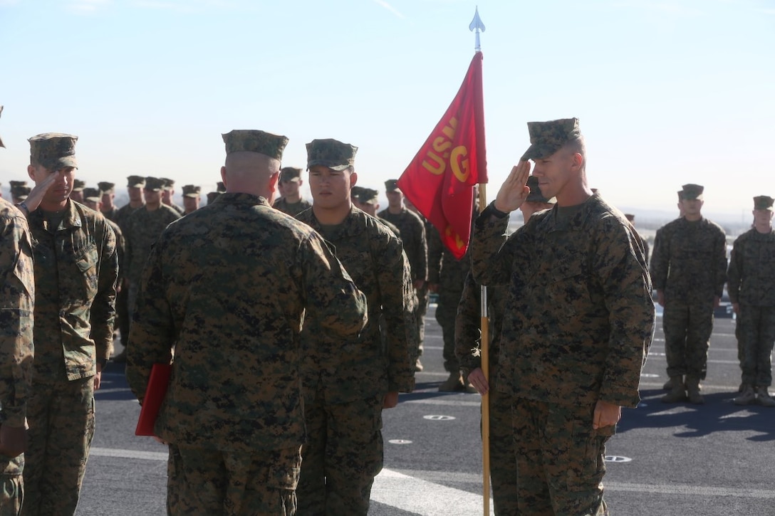 John Tey, center, a U.S. Marine infantryman with the 13th Marine Expeditionary Unit, stands at attention while two of his mentors salute their commander before Tey's promotion at his ceremony during Certification Exercise, Dec. 3, 2015. Corporal is the first noncommissioned officer rank in the Marine Corps, and comes with increased authority as well as increased responsibility. (U.S. Marine Corps photo by Sgt. Paris Capers/RELEASED)